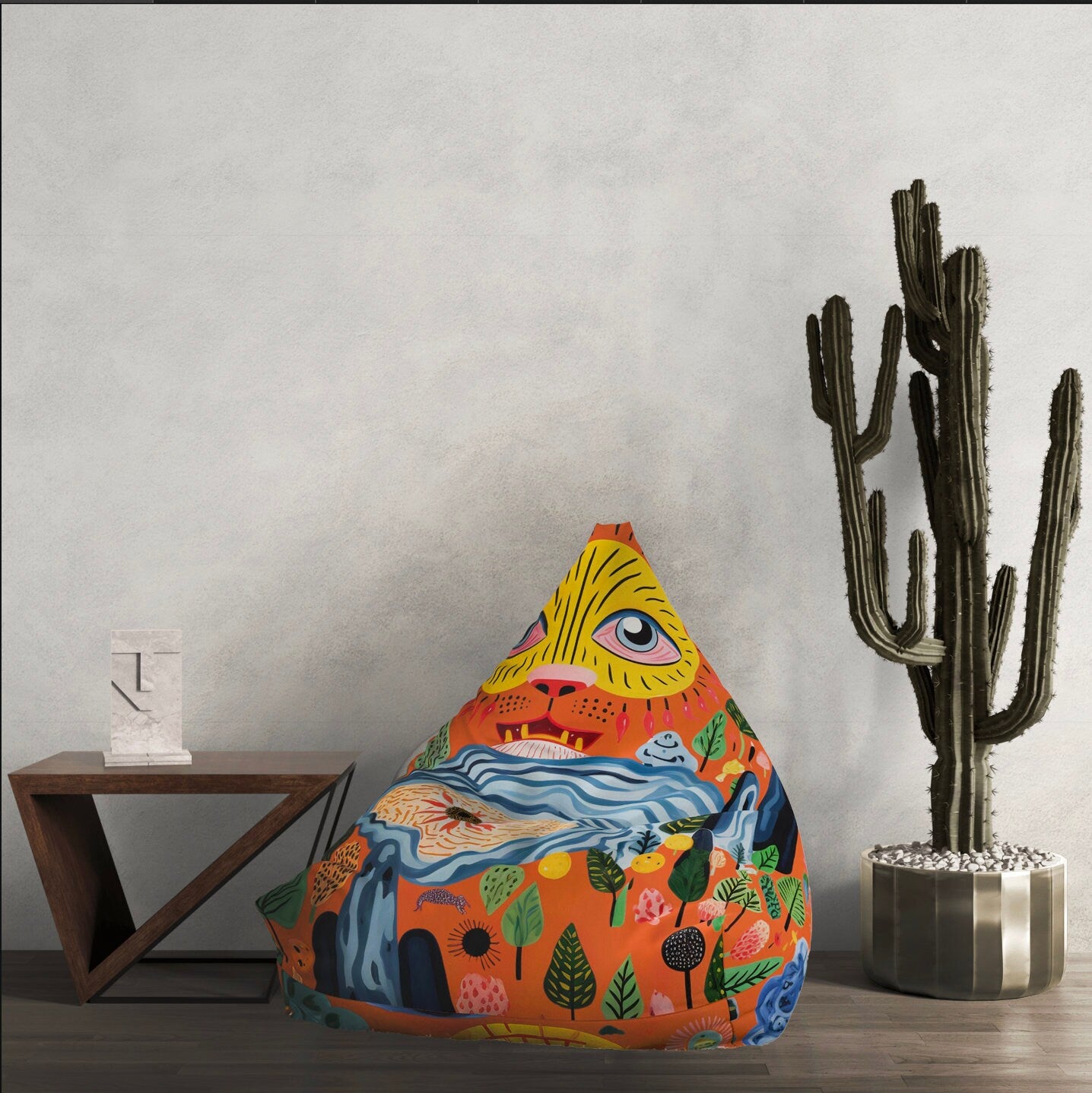 a triangle shaped pillow sitting next to a cactus